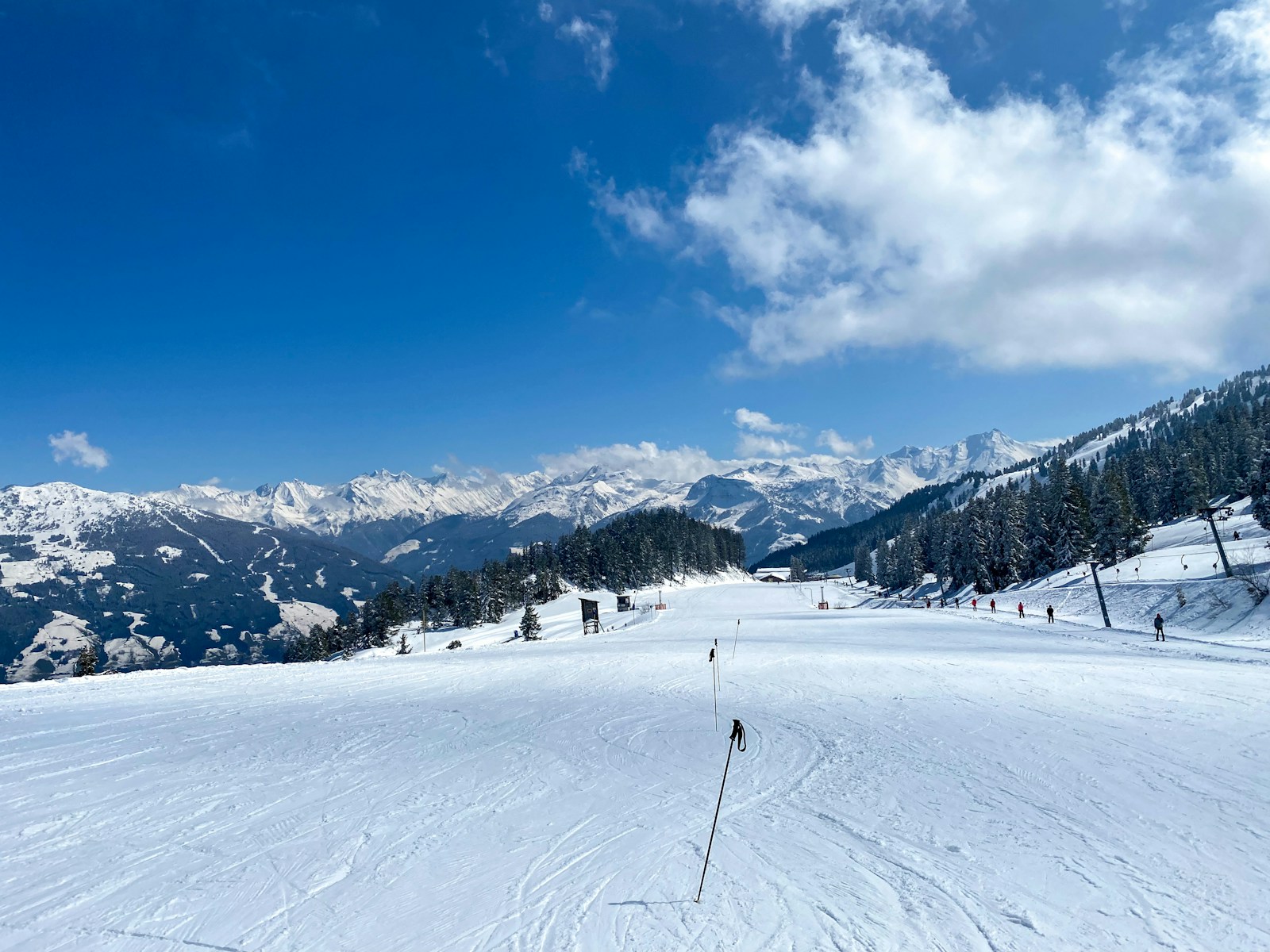 藍天下的雪道、積雪山峰及雪場纜索設施